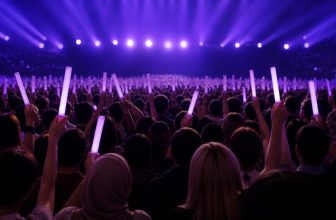 Purple concert lights above a diverse music audience holding plain light sticks